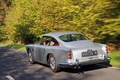 Aston Martin DB4 gris 3/4 arrière gauche travelling penché 2