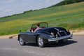 Jaguar XK150 Roadster noir rond-point 3/4 arrière gauche