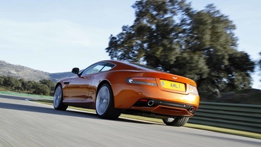 Aston Martin Virage orange 3/4 arrière gauche travelling penché