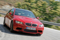 BMW M3 rouge 3/4 avant droit travelling penché