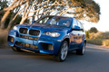 BMW X5 M bleu 3/4 avant gauche travelling penché