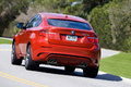 BMW X6 M rouge 3/4 arrière gauche penché