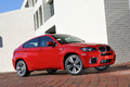 BMW X6 M rouge 3/4 avant droit penché