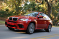 BMW X6 M rouge 3/4 avant gauche travelling penché 2