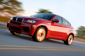 BMW X6 M rouge 3/4 avant gauche travelling penché 3