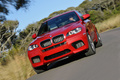 BMW X6 M rouge 3/4 avant gauche travelling penché