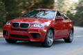 BMW X6 M rouge 3/4 avant gauche travelling