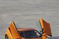 McLaren MP4-12C orange 3/4 avant gauche portes ouvertes vue de haut debout