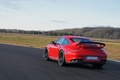 Porsche 997 GT2 RS rouge 3/4 arrière gauche travelling penché