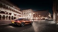 Aston Martin Vanquish II orange 3/4 arrière droit travelling penché