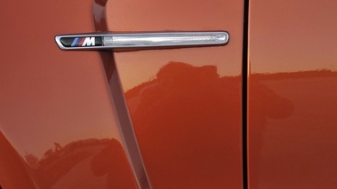 BMW Série 1M orange logo aile debout