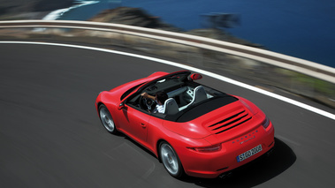 Porsche 991 Carrera S Cabriolet rouge 3/4 arrière gauche travelling vue de haut