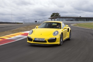 Porsche 991 Turbo S jaune vue de 3/4 avant gauche en travelling