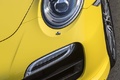 Porsche 991 Turbo S jaune phares avant debout