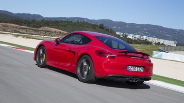 Porsche Cayman S II rouge 3/4 arrière gauche travelling penché