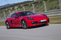 Porsche Cayman S II rouge 3/4 avant droit travelling penché