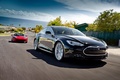 Tesla Model S noir 3/4 avant droit & Roadster Sport rouge face avant travelling penché